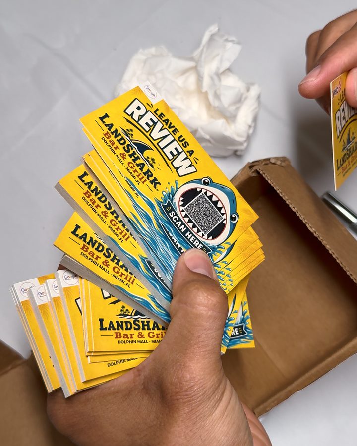 Printed pieces with a review QR code, in the hand